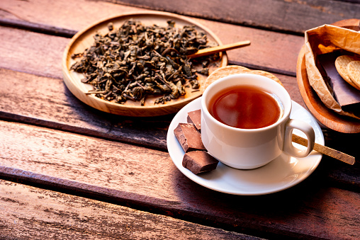 Dipping tea bag in a cup of hot water.