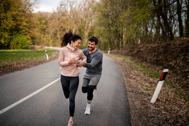 istock Happy athletic couple having fun while running in spring day 1443093048