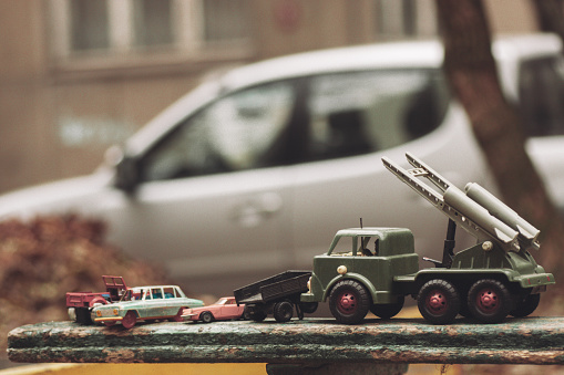 Soviet military toy cars on a bench on the street