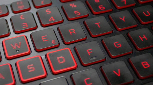 バックライト付きキーボードのクローズアップ。赤いバックライト付き文字を持つ黒鍵 - alphabet characters close up color image ストックフォトと画像