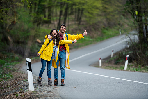 Backpackers hitchhiking on the road