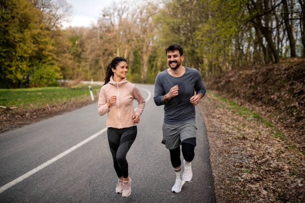 istock Happy athletic couple having fun while running in spring day 1443098625