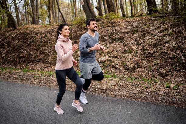 istock Happy athletic couple having fun while running in spring day 1443098644