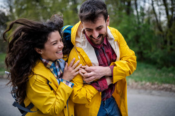 istock Happy affectionate couple in raincoats enjoying in nature 1443100543