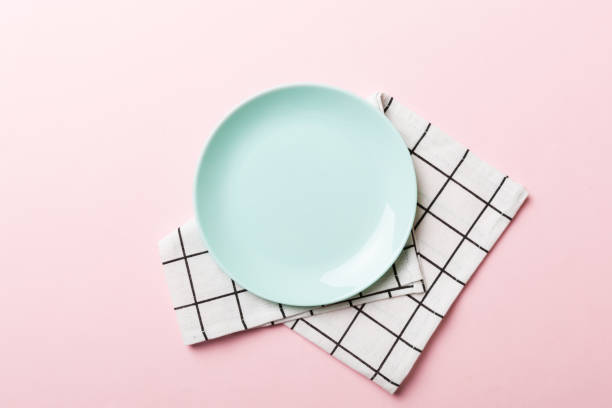 istock Top view on colored background empty round blue plate on tablecloth for food. Empty dish on napkin with space for your design 1443102646