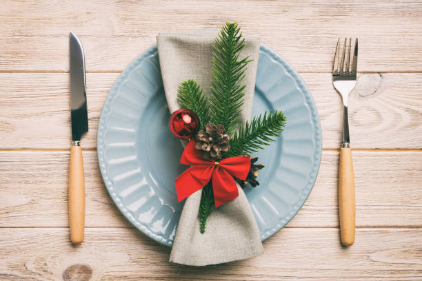 istock Christmas table place setting with christmas decor and plates, kine, fork and spoon. Christmas holiday background. Top view 1443102730