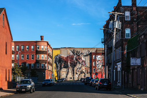 Holyoke, Massachusetts, USA - Streets of inner city, large mural “Father and Baby Moose” (built almost exclusively with garbage) by Bordalo in the background.