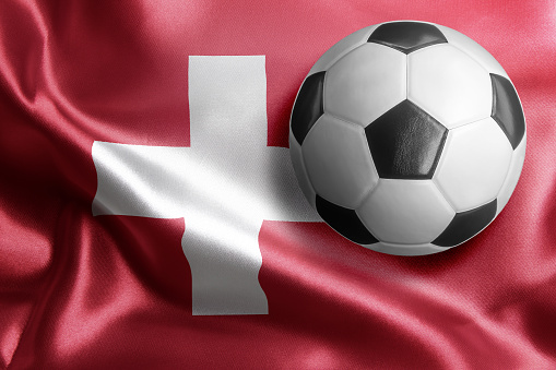 Soccer ball on flag of Switzerland. Horizontal orientation. No people.