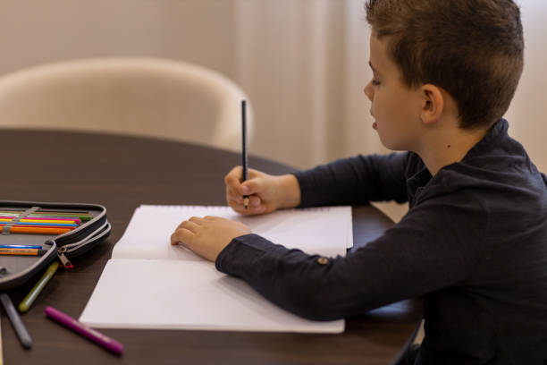 istock Young boy drawing in his coloring book 1443104215