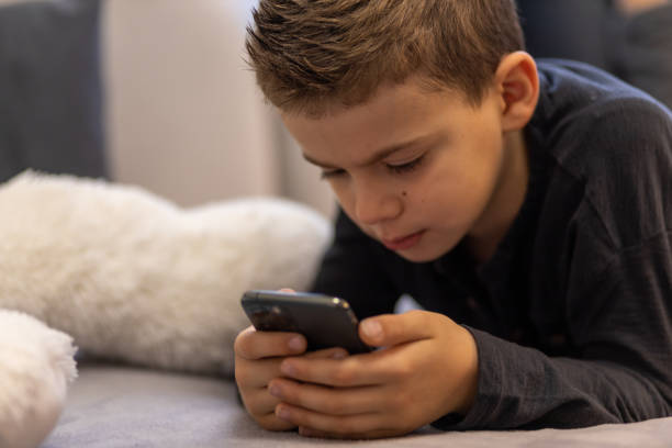 istock Close-up of a young boy playing with phone 1443105638