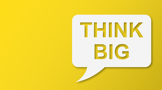 Think Big Speech Bubbles with Copy Space On Yellow Cardboard Background