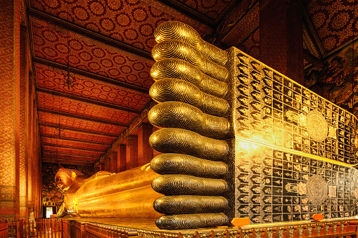 famous golden reclining buddha statue in Buddhist temple at wat pho travel destination and tourist attraction in Bangkok Thailand