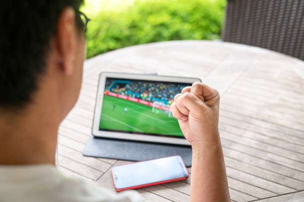 ver el partido de fútbol en una tableta digital. - match sport leisure games sport apps fotografías e imágenes de stock