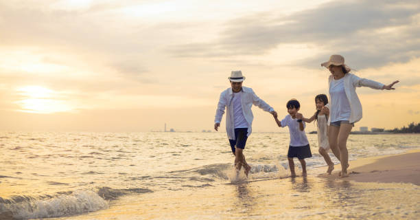 istock Happy family having fun running on a sandy beach at sunset time 1443145346