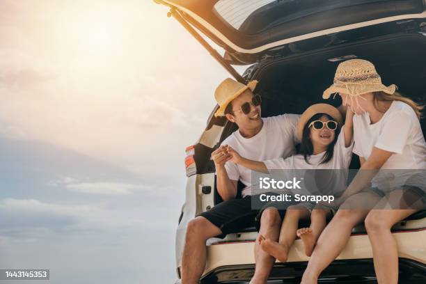 Dad Mom And Daughter Enjoying Road Trip Sitting On Back Car Stock Photo - Download Image Now