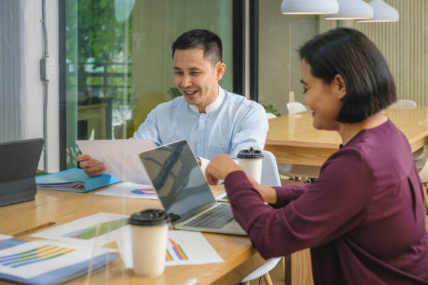 istock Two Asian people colleagues working together and discussing on new project at modern office 1443153792