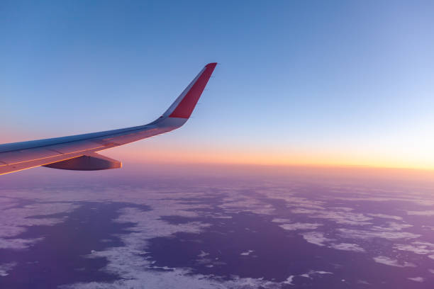 istock Airplane flight. Aircraft's wing and land seen through the illuminator 1443165528