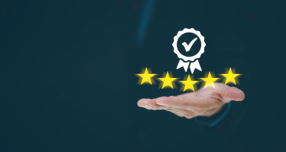 Businessman Hand shows the sign of the top service Quality assurance 5 star on the black background, Guarantee, Standards, ISO certification and standardization concept.