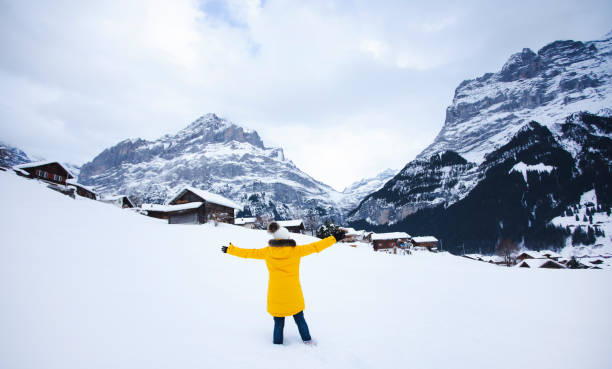 Grindelwald Switzerland top of Europe, Asian woman wearing yellow coat.She is feel Very happy on vacation in the mountains Background.travel trip  Snowy winter on Mount Grindelwald in Switzerland, Grindelwald Switzerland top of Europe, Asian woman wearing yellow coat.She is feel Very happy on vacation in the mountains Background.travel trip  Snowy winter on Mount Grindelwald in Switzerland, switzerland european alps ski winter stock pictures, royalty-free photos & images