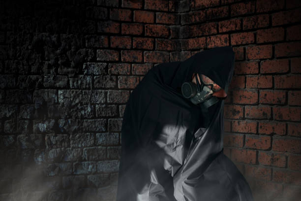 istock Man wearing a respirator under a black raincoat during a gas attack 1443169751