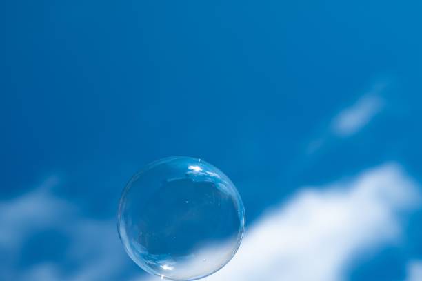 istock Closeup of a single soap bubble with a cloudy blue sky in the background 1443170380