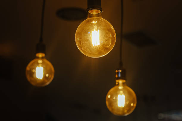 istock Closeup shot of three light bulbs hanging from the ceiling 1443171135