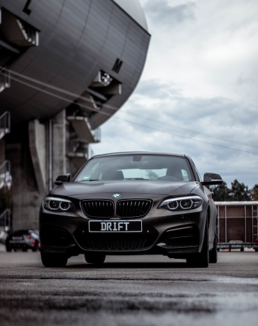 Hockenhei, Germany – August 07, 2021: A vertical shot of a black BMW car with Drift written on the license plate