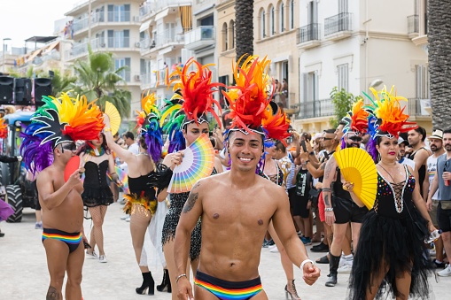 Sitges, Spain – June 12, 2022: Sitges, Spain - June 12, 2022: Smiling man looking at camera celebrating pride flag event in Sitges, Spain.