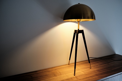 A luxury brass table lamp on a cabinet at night
