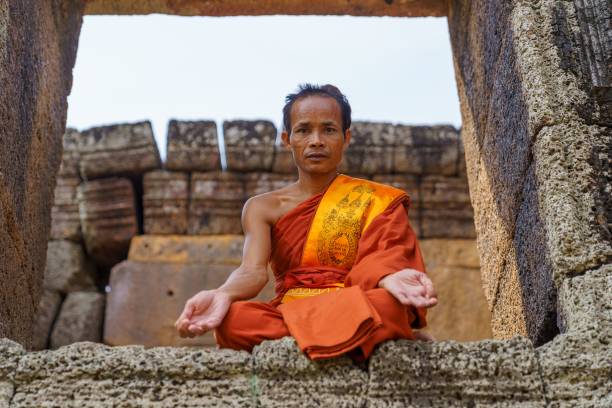 Monks and tourists in front of the West Entrance of Angkor Wat in Siem Reap, Cambodia