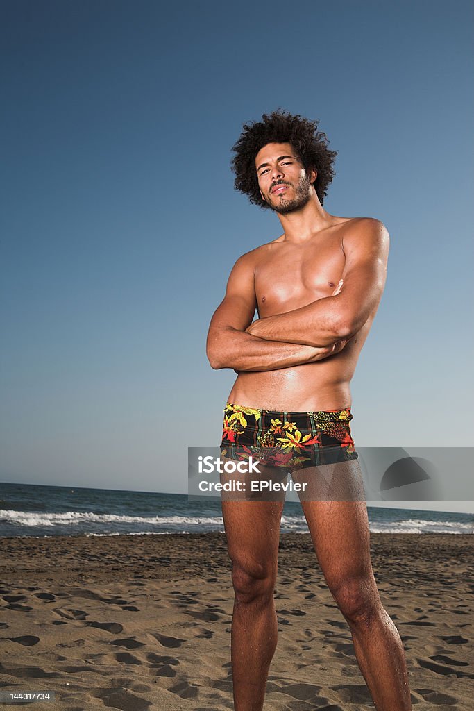 Hombre de pie en la playa - Foto de stock de Afrodescendiente libre de derechos