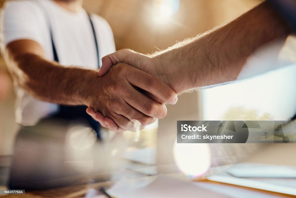 Successful agreement at construction site! Close up of unrecognizable workers came to an agreement at construction site. Handshake Stock Photo