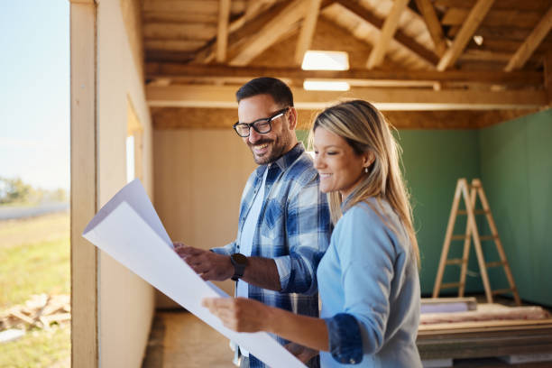 istock Happy couple reading blueprints of their developing house. 1443178861