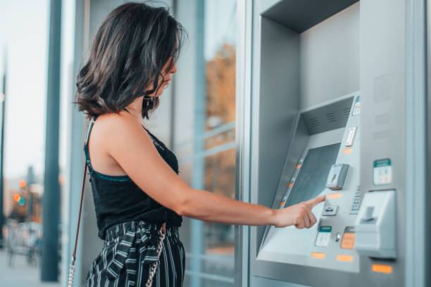 istock Caucasian female model standing by an ATM 1443179034