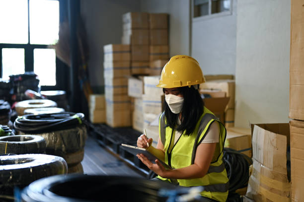 istock Professional Asian female warehouse worker or female QC engineer working in warehouse 1443179103