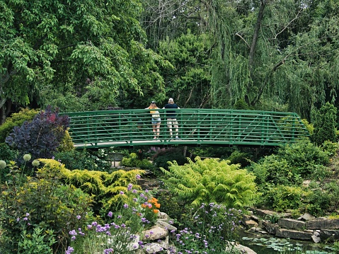 Overland Park, United States – June 12, 2022: A couple standing on the bridge of Claude Monet garden in Giverny, France