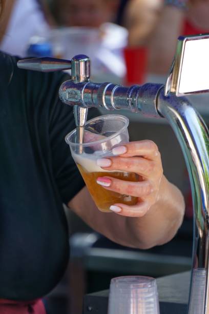 istock woman with painted fingernails serving a draught beer with foam 1443179419