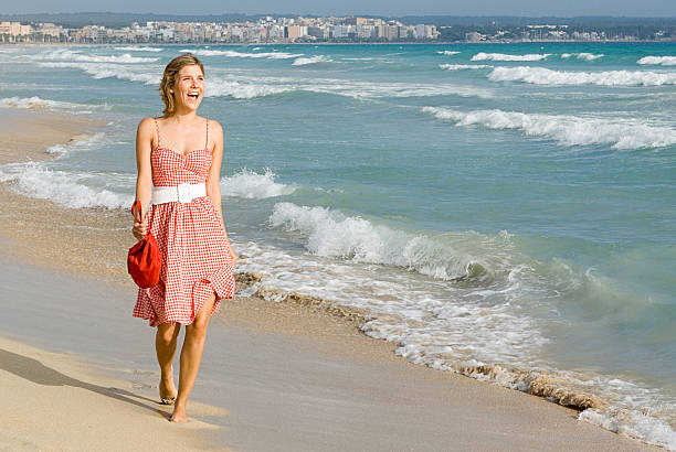 girl on vacation taking walk along seashore stock photo