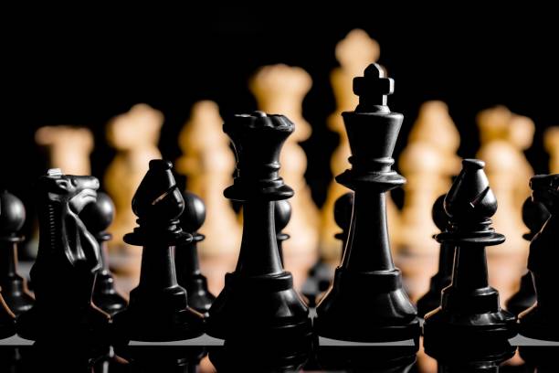 istock A Close up of Chess pieces on a reflective mirror board surface with a plain black background 1443180143