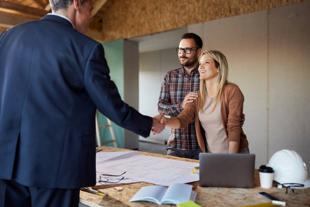 istock Happy couple came to an agreement with architect at construction site. 1443181307