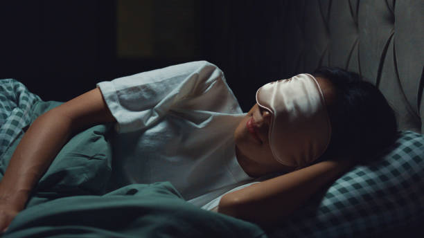 Young beautiful Asia girl lay on bed soft pillow wear eyes mask relaxing from work deep breath sleep tight and well on comfort bed in bedroom cozy home at night. Young beautiful Asia girl lay on bed soft pillow wear eyes mask relaxing from work deep breath sleep tight and well on comfort bed in bedroom cozy home at night. Restart energy, sleeping time concept. woman sleeping in bed at night stock pictures, royalty-free photos & images