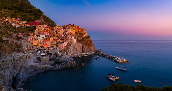 Picturesque traditional bright colorful houses in iconic old town of Manarola, romantic village in Cinque Terre on Mediterranean Sea, Italy at sunset