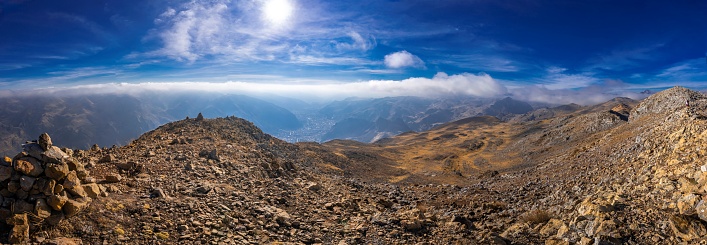 A panoramic view of the city of Huancavelica, Peru, from a viewpoint on a sunny day with mist
