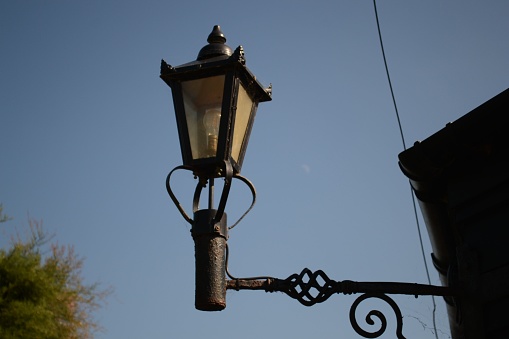 An old street lamp against a blue sky.