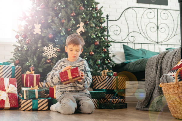 istock Cute little boy holding a gift box for Christmas 1443185239