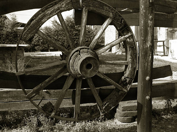 Old-time wagon wheel, wooden spokes, part of a horse-drawn wagon, good detail and texture.