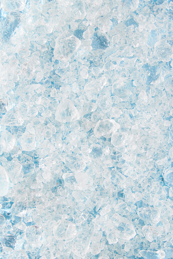 Close up crushed ice in sunlight. Summer pattern background refreshment concept. Flat lay top view