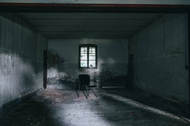 An interior view of an empty and abandoned building with a single chair