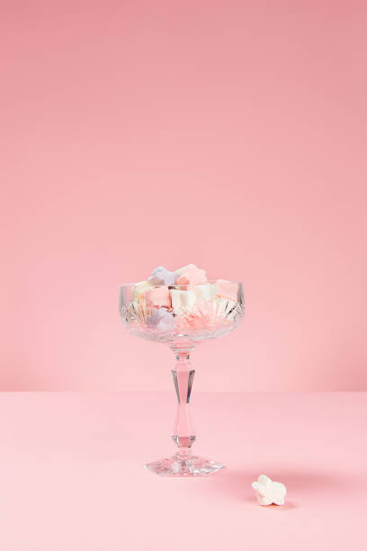 istock Marshmallows in star shape in a glass on pink background 1443188844
