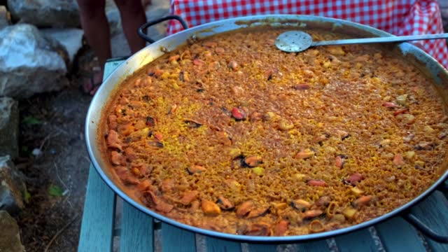 People getting traditional Spanish seafood paella